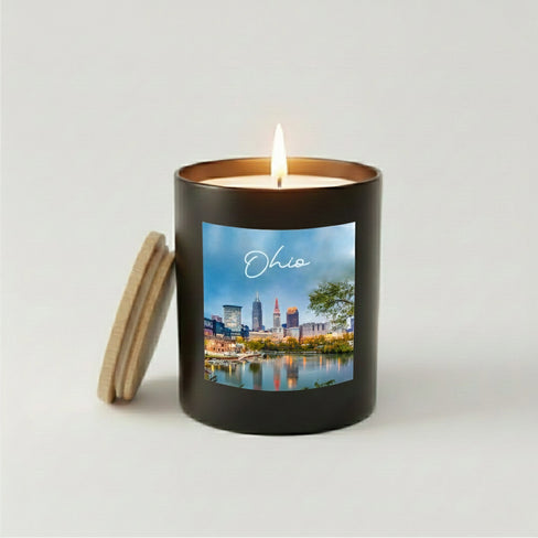 Lit Ohio skyline candle in a black jar with a wooden lid.