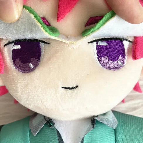 Close-up of a plush toy with large purple eyes and a green outfit.